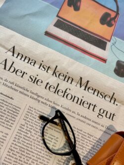 关于《安娜》的报纸文章，旁边放着眼镜和眼镜盒。