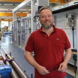 莫里茨·馮·索登身穿紅色Polo衫，在博爾內曼的生產車間裡。