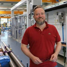 莫里茨·馮·索登身穿紅色Polo衫，在博爾內曼的生產車間裡。