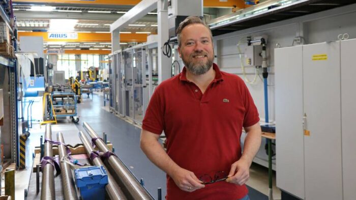 莫里茨·馮·索登身穿紅色Polo衫，在博爾內曼的生產車間裡。