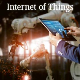 人員使用平板電腦操作工業機器人，火花四濺，字樣「物聯網」